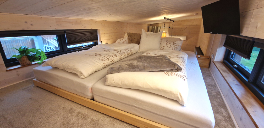 Gemütliches Doppelbett im Tiny House im oberen Stockwerk.
